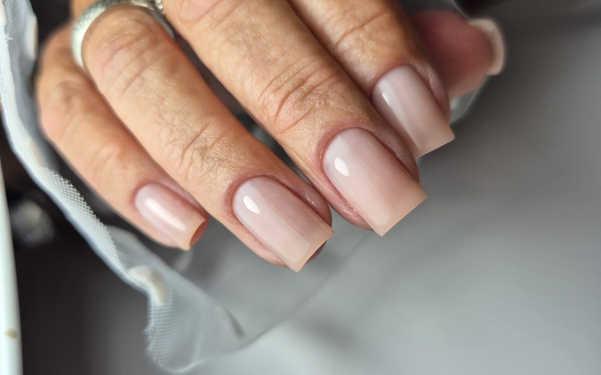 Zachte nude gelnagels, square gevijld, met ringen, op wit tule