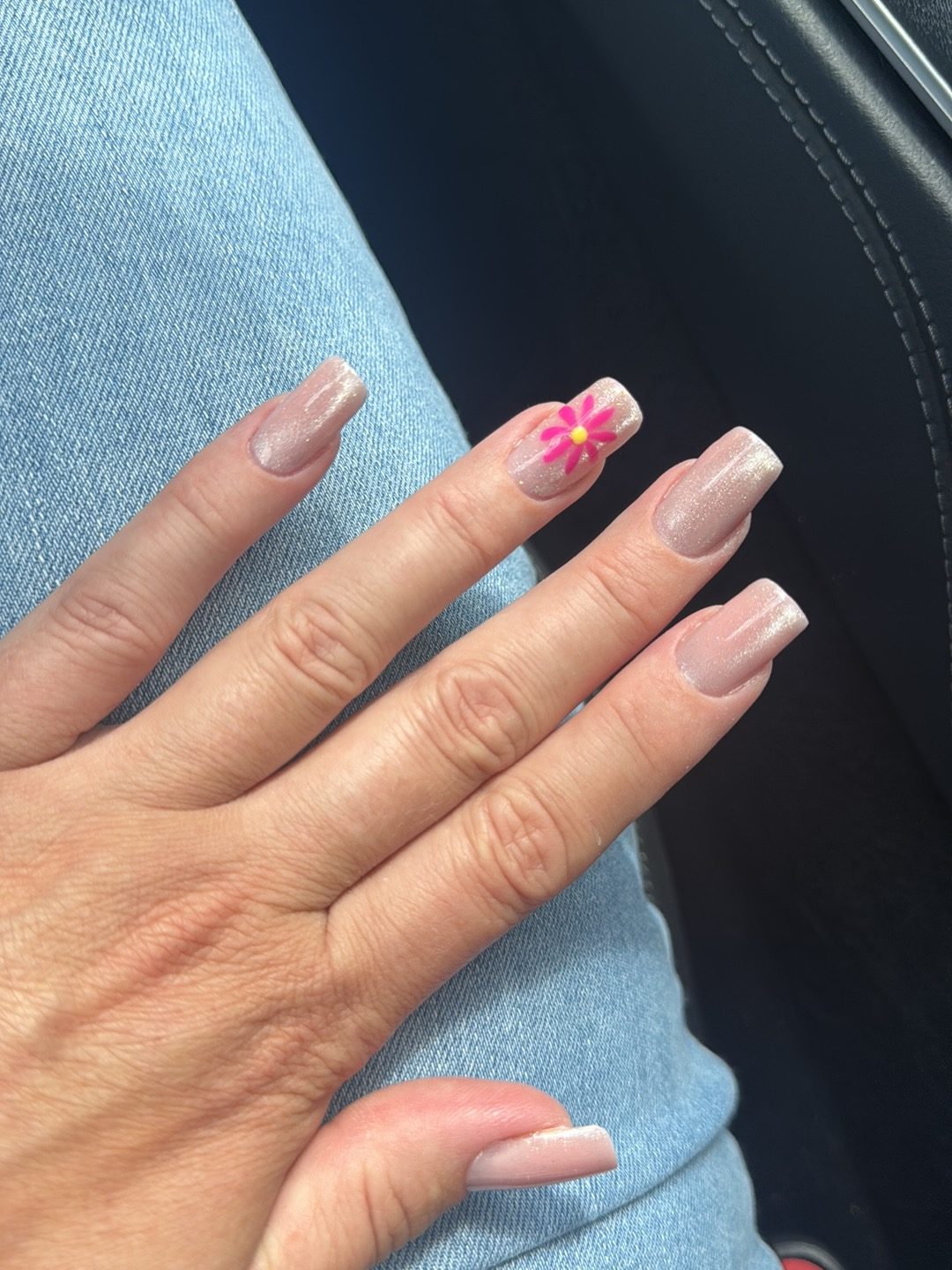 Nude square nagels met een roze bloem als accent
